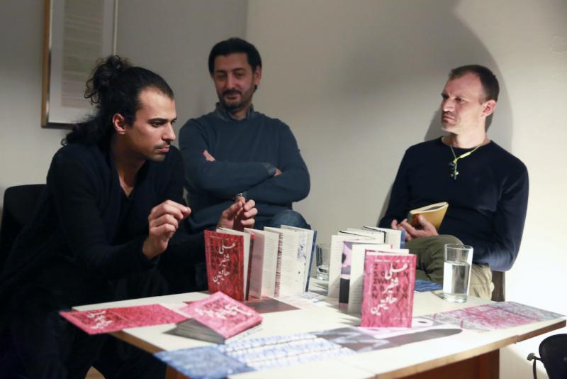 Buchpräsentation in den Räumen des Falschrum Verlags. Der Designer Ayman Hassan präsentiert das Künstlerbuch "Zwischen zwei Abgründen" von Abdullah Alqaseer, neben ihm sitzen der Autor und der Verfasser des Vorworts