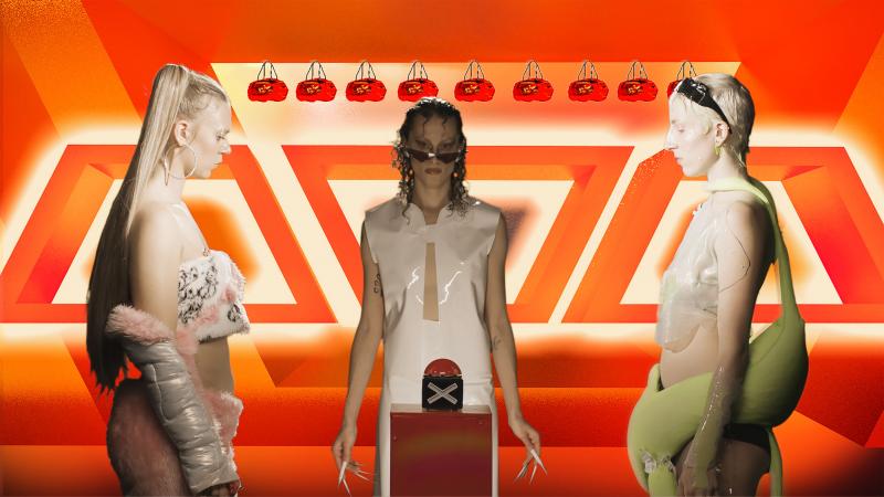 Drei weibliche Personen in futuristischen Kostümen, die vor einem roten Gameshow-Hintergrund stehen. In der Mitte von ihnene befidnet sich ein Buzzer.