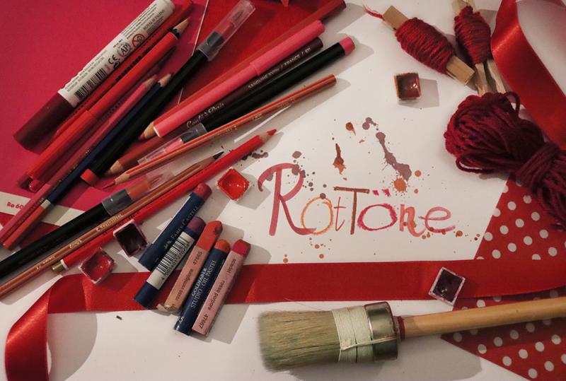 Bild verschiedener roter Kunstmaterialien (Filzstifte, Papier, Pinsel, Kreiden, Wollschnur) und Schriftzug Rottöne