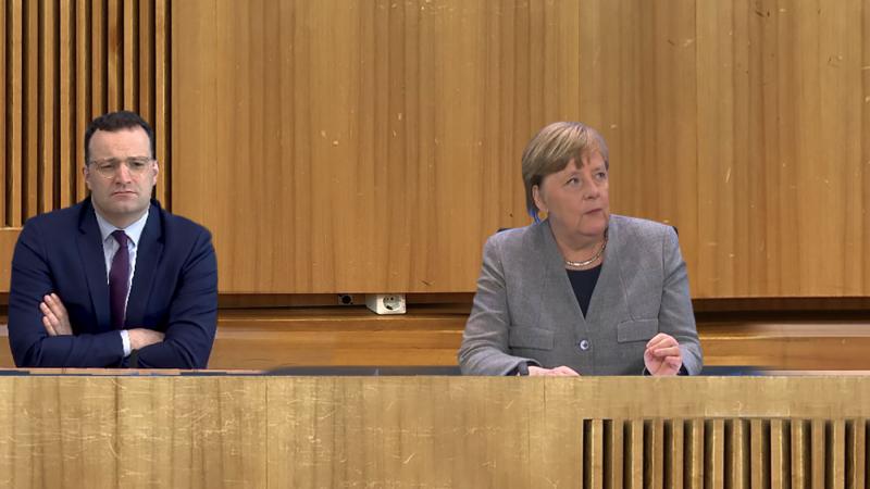 Videostill: Spahn und Merkel sitzen an einem digital konstruierten Podium der Bundespressekonferenz.