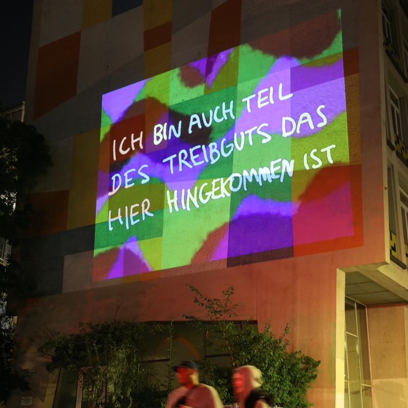  Projektion eines Textes mit der Aufschrift: ich bin auch teil des Treibgut der hiergekommen ist