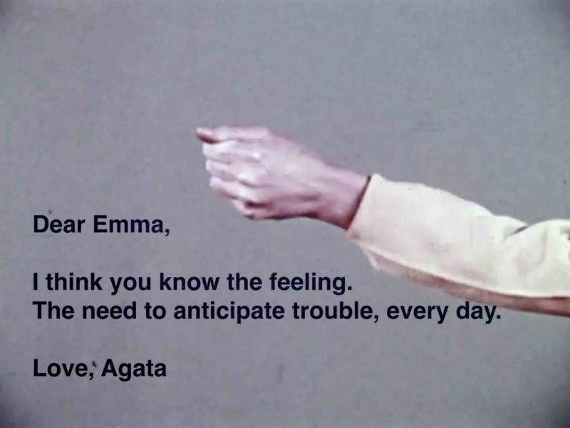 Image of a hand held in a fist against gray background. A text that says: "Dear Emma, I think you know the feeling. The need to anticipate trouble, every day. Love, Agata"