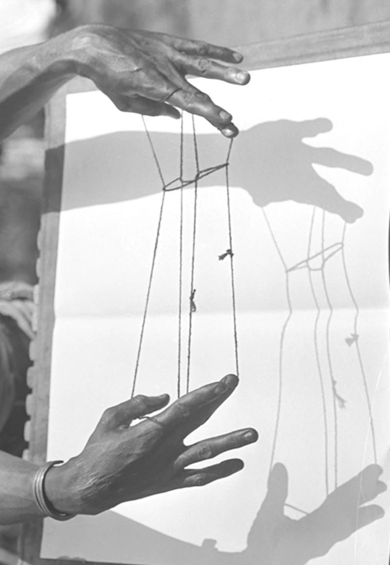Hands making a string figure with a shadow