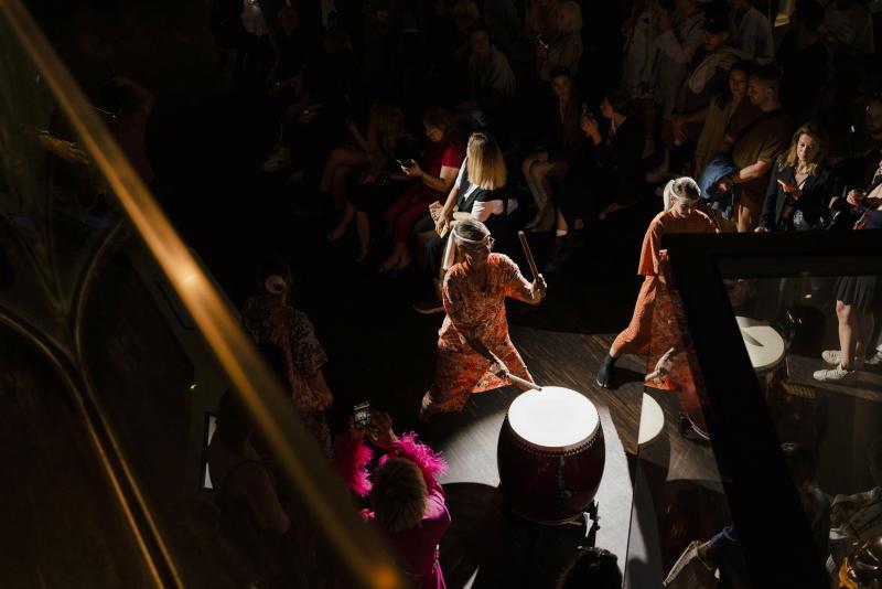 Blick von oben auf Trommler und Publikum in japanischer Mode und im dramatischen Scheinwerferlicht