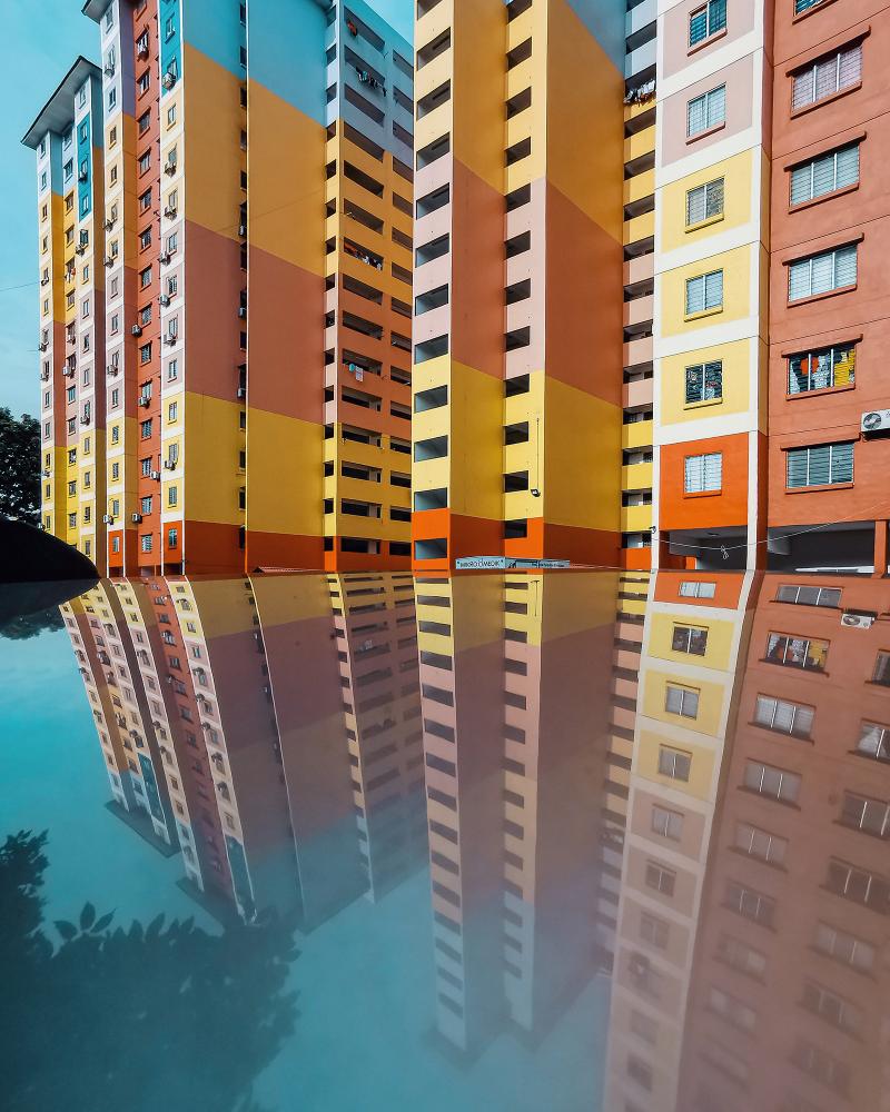 Ein buntes Plattenhaus und seine Spiegelung 