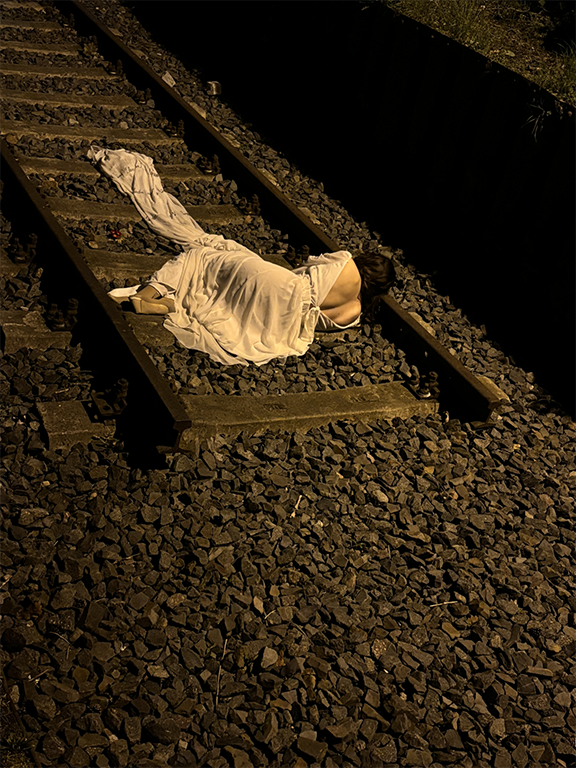 woman on train tracks in Berlin, which originally led to Auschwitz