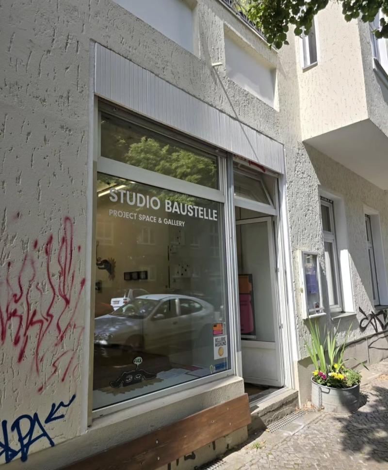 Eingangsfenster des Projektraumes Studio Baustelle. Spiegelung eines Autos im Fenster