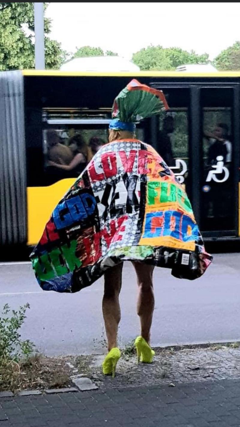 Eine Person in einem bunten Mantel vor der Strasse