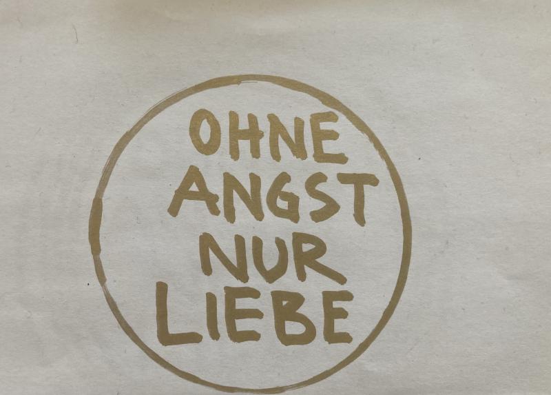 Ein einfacher handgemalter Kreis mit der goldenen Botschaft: „OHNE ANGST NUR LIEBE“.
