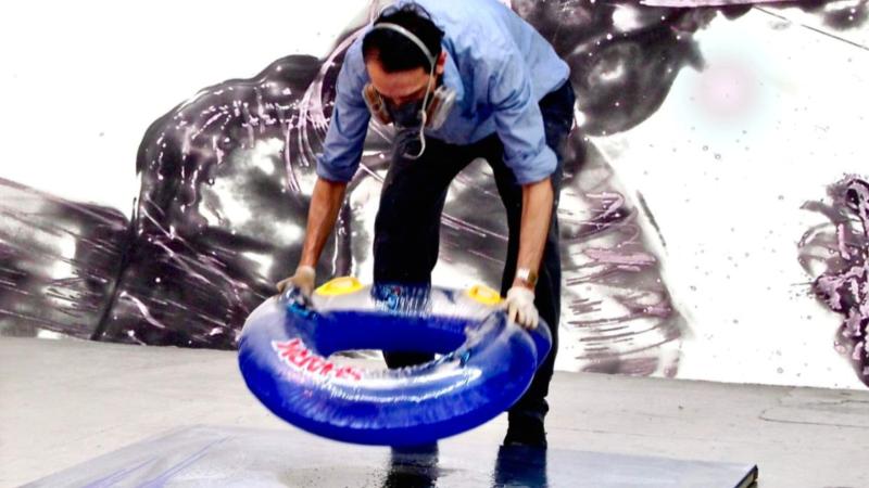 Studioansicht artist Robert Lanz malt mit Schwimmreifen.