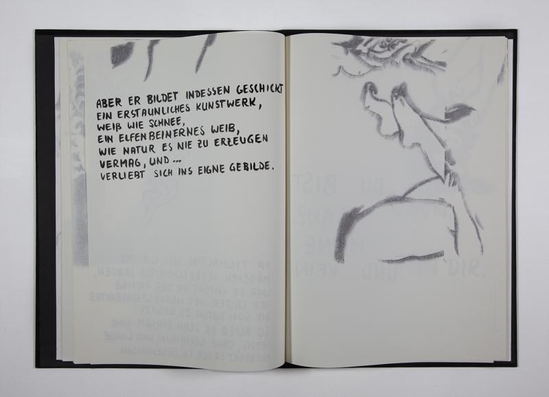 Zu sehen ist ein aufgeschlagenes Buch mit schwarzem Einband. Die linke geöffnete Seite zeigt einen per Hand geschriebenen Text, die andere Seite eine leicht verschwommene Zeichnung von Beinen.