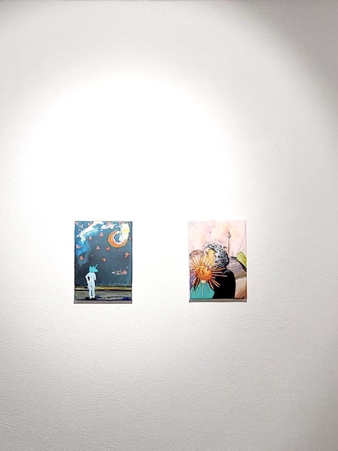 Two paintings on the wall.  Surrealistic images in her created spaces.