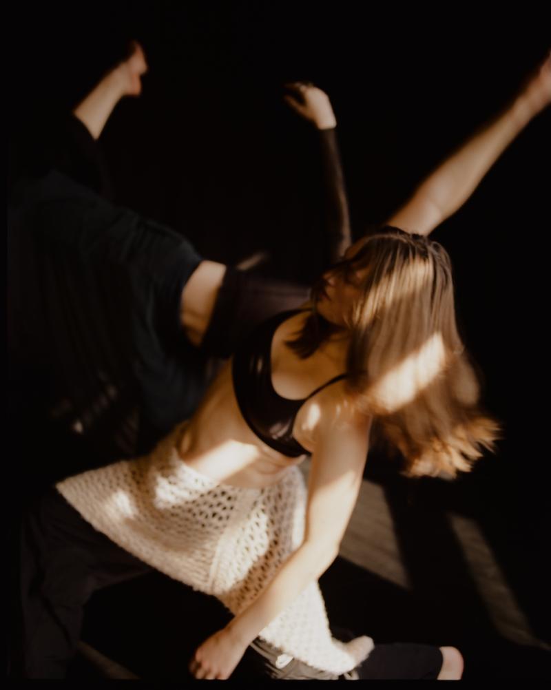 two dancers move with light filtering in on their bodies