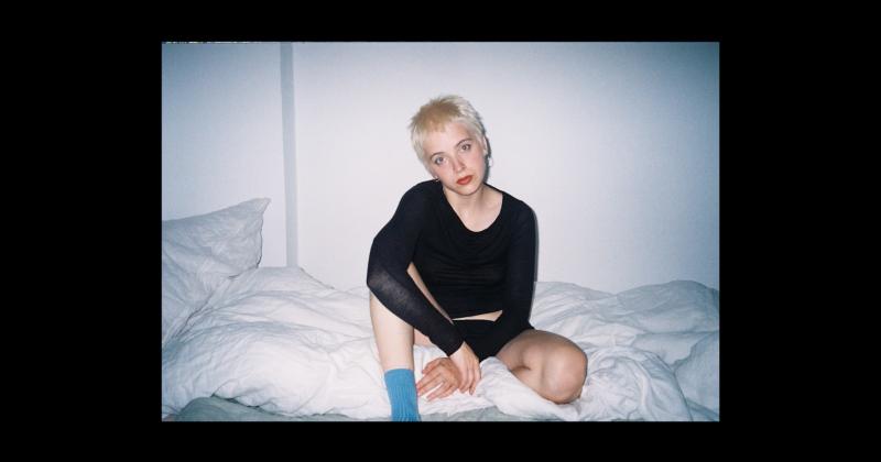 Filmstill, Analog Foto, Selbstporträt von einem sitzenden Menschen auf einem Bett