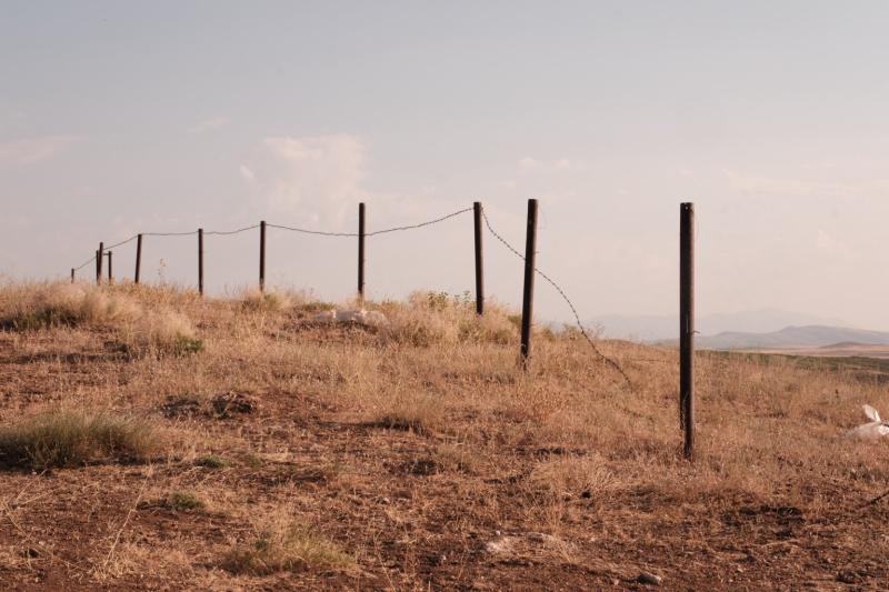 Eine trockene Landschaft im Herzen Anatoliens. Der einfache Drahtzaun markiert eine Grenze, die zugleich durchlässig wirkt – ein stilles Bild über Übergänge, Entfernung und Zugehörigkeit.
