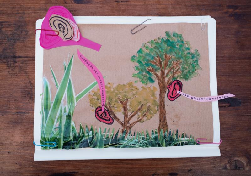 A collage of one small tree and one larger tree with giant ears coming out of each one. Out of the ears are a string of letters to evoke the idea of sound.   Eine Collage aus einem kleinen und einem größeren Baum, aus deren Stämmen jeweils übergroße Ohren wachsen. Aus den Ohren entfaltet sich eine Kette aus Buchstaben, die den Eindruck von Klang entstehen lässt.