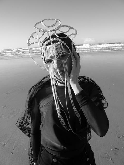 Foto aus Videoperformance "The ambivalence of the Mask", Carla Nunes trägt Maske aus Perlen und Augen