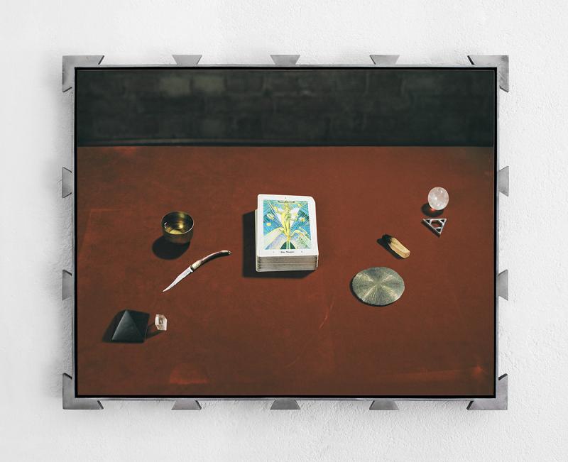 Still life composition of a Thoth Tarot deck portraying “The Magus” Trump and its four elements, in hand-made frame with triangular motifs.