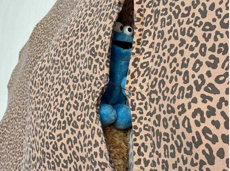Eine Detailaufnahme einer künstlerischen Arbeit von Rosa Witt. Zu sehen ist ein blaues Kuscheltier, eingenäht in eine leopardengemusterte Bettdecke.