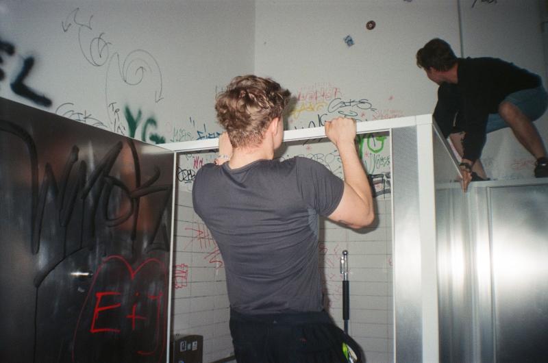 2 Jungs in einem Toilettenzimmer voller Graffiti 