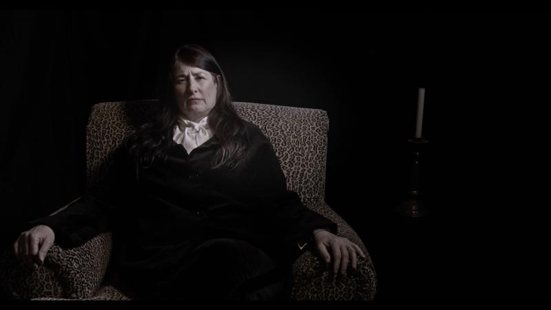Artist is in a surreal dark space for her performance.