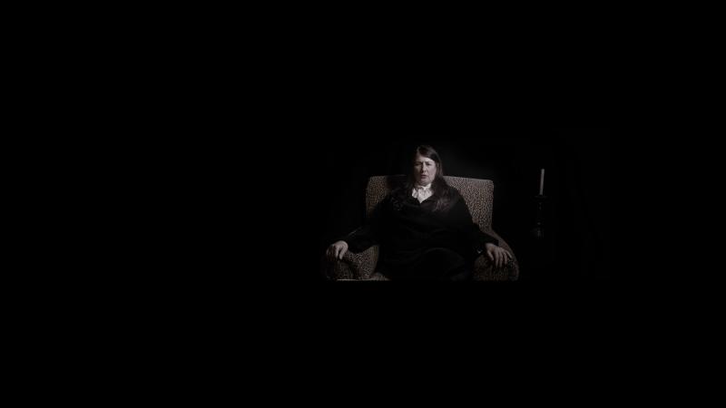 Artist is in a surreal dark space for her performance.