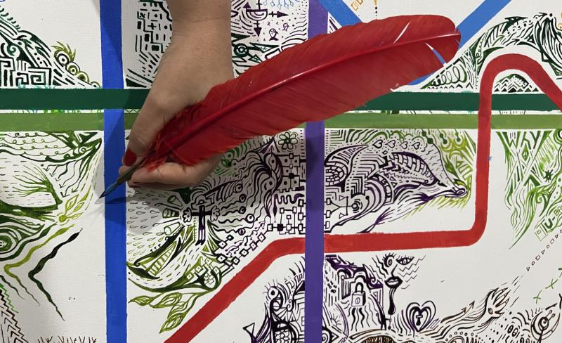 Close-up of Mirela Fioresy drawing with a dip pen on a canvas from the [SUB] WAYS Series.