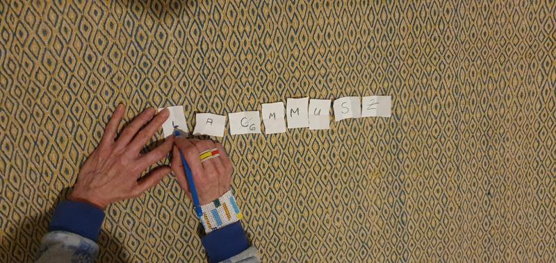 der Titel der Ausstellung als Buchstabenreihe auf Papier