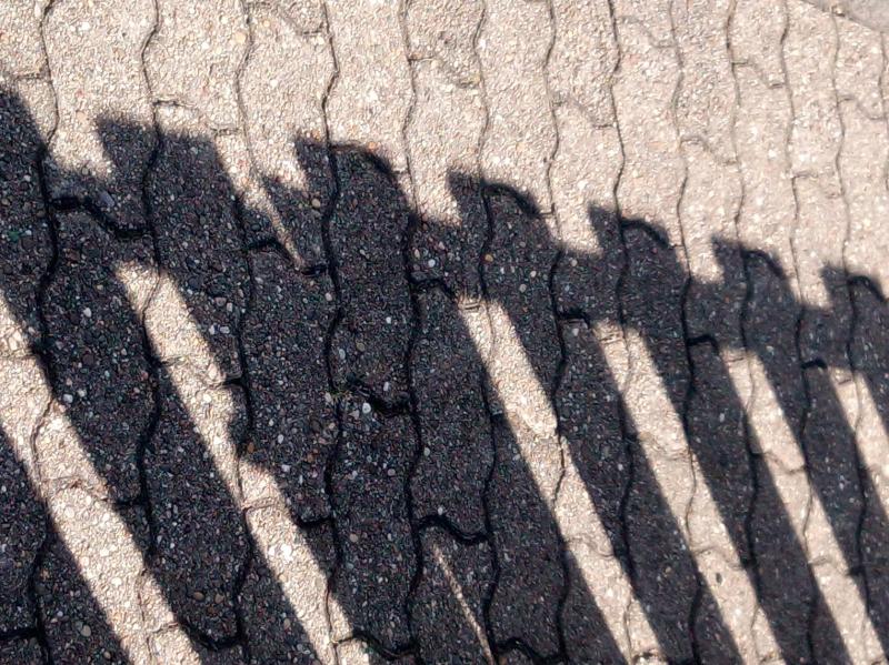 Pflastersteine mit Gartenzaunschatten