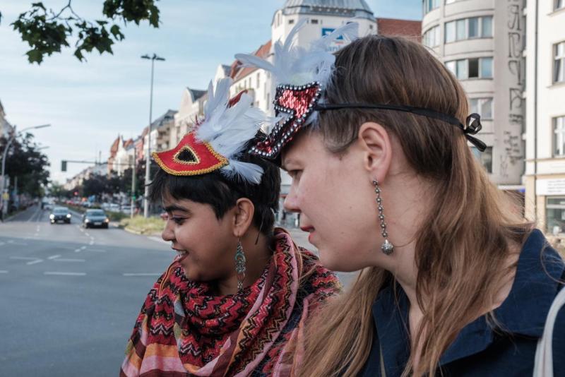 Das Foto zeigt zwei Personen mit vogelartigen Masken auf der Sonnenallee.