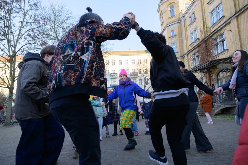 Menschen tanzen im Kreis vorm Jungen Tanzhaus 