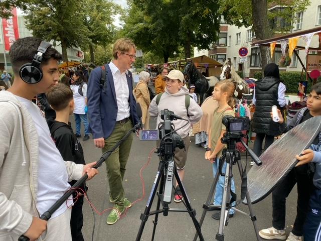 Kinder aus dem Harzer Kiez führen im Rahmen des Filmprojekts ein Interview mit Bezirksstadtrat Jochen Biedermann auf dem Harzer Kiezfest.