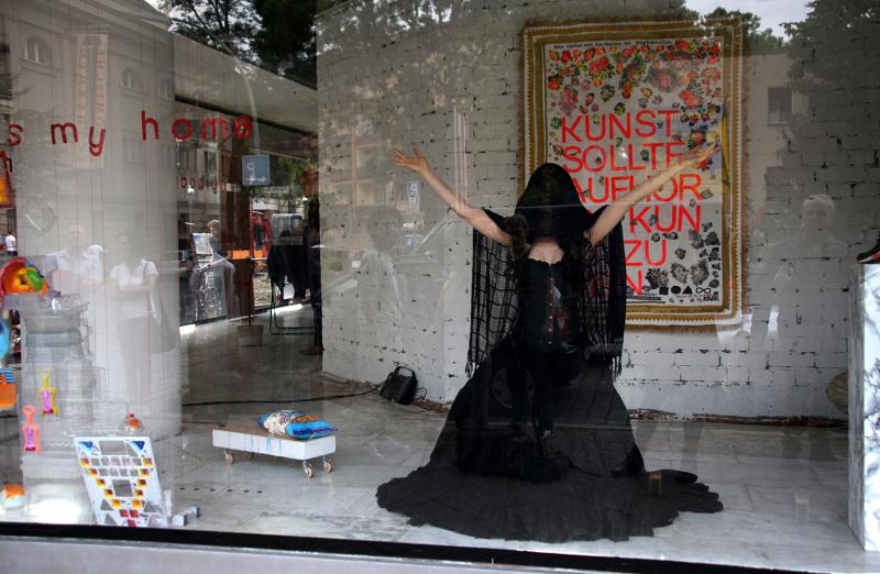 Schauspielerin in einem schwarzen Kleid in einem Schaufenster
